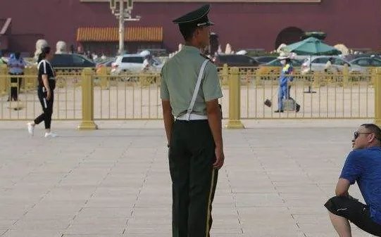 游客为雨中执勤哨兵撑伞,我们是否该像这名游客学习?
